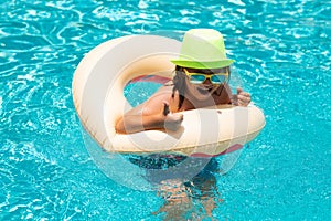 Happy child enjoying summer vacation outdoors in the water in the swimming pool.