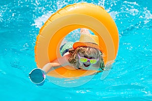 Happy child enjoying summer vacation outdoors in the water in the swimming pool.