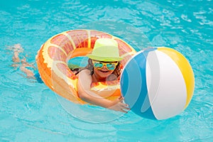 Happy child enjoying summer vacation outdoors in the water in the swimming pool.