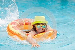 Happy child enjoying summer vacation outdoors in the water in the swimming pool.