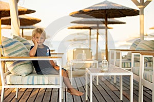 Happy child with family, ejoying the beach alley in Sarti, Greece on sunset