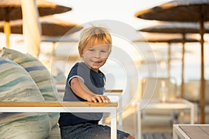 Happy child with family, ejoying the beach alley in Sarti, Greece on sunset