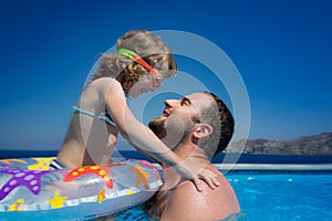 Happy child with father in swimming pool