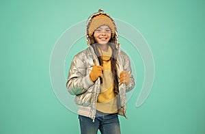 happy child feel comfortable and warm in padded jacket and knitted clothing in winter weather, cold climate