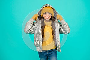 Happy child feel comfortable and warm in padded jacket and knitted clothing in winter weather, cold winter