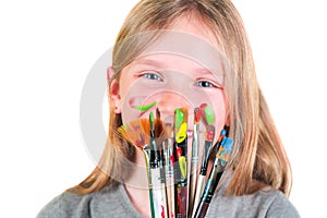 Happy child girl artist with brushes and palette in hands on white background. Painting education concept, art school