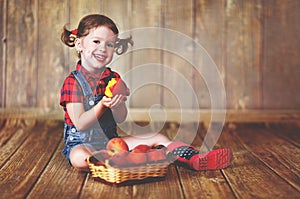 Happy child girl with a basket of peaches