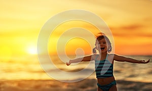 Happy child girl in bikini on beach in summer sea