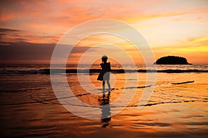 Happy child girl black silhouette on sun background. Kid having fun by water pool along sea on beach. Travel lifestyle, summer