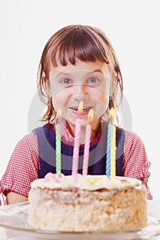 Happy child girl with cake and candle celebrating her birthday. Holiday, happiness, childhood concept