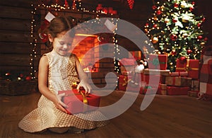 Happy child girl with christmas gift at home