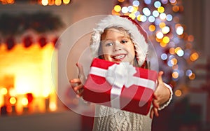 Happy child girl with christmas present at home