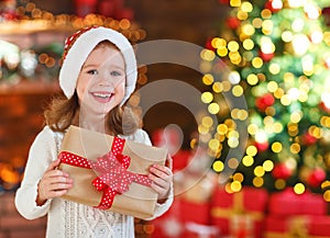 Happy child girl with christmas present at home