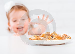 Happy child girl eats cookies and milk