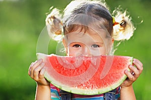 Happy child girl eats watermelon