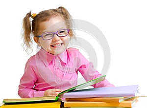 Happy child girl in glasses reading books sitting photo