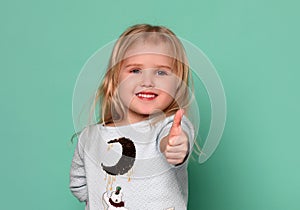 Happy child girl with hands thumbs up