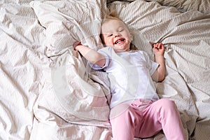 Happy child girl having fun jumping and playing funny active game in parents bed, Bouncing, fooling around, frolics