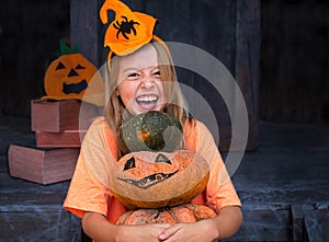 Happy child girl holding pumpkin