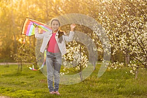 happy child girl with a kite running on meadow in nature.