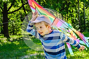 Happy child girl with a kite running on meadow in summer in nature