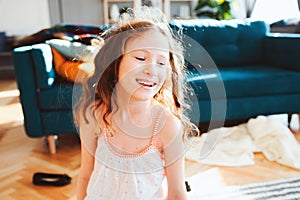 Happy child girl playing at home in cozy weekend morning