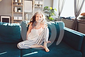 Happy child girl playing at home in cozy weekend morning
