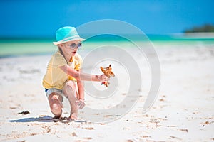 Happy child girl playing with toy airplane on the beach. Kids dream of becoming a pilot