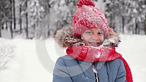 Happy child girl plays with a snow in winter day. Girl enjoys winter, frosty day.