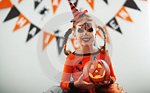 Happy child girl in pumpkin costume to halloween