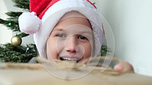 Happy child girl receiving Christmas gift box from parents near Christmas tree