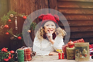 Feliz en un sombrero a bufanda embalaje regalos de navidad sobre el acogedor países casa decorado nuevo a 