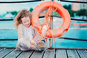 Happy child girl with rescue ring with sea background, safety on the water concept