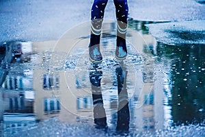 Happy child girl running and jumping in puddles after rain. Childhood, laisure, happiness concept. Horizontal image