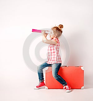 Happy child girl with spyglass, explore and adventure concept