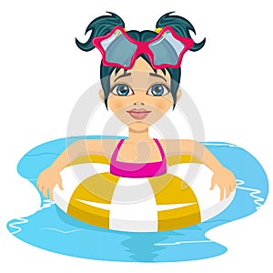 Happy child girl swimming in pool on inflatable ring