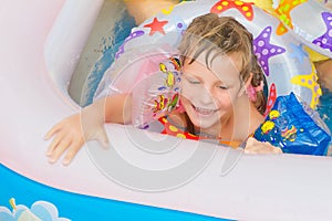 Happy child girl swimming in pool with swimming ring