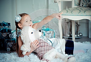 Happy child girl with toy in christmas decoration room. Toned photo