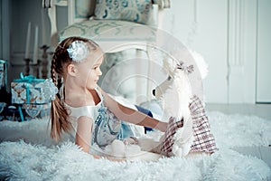 Happy child girl with toy in christmas decoration room. Toned photo