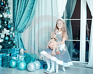 Happy child girl with toy in christmas decoration room. Toned photo