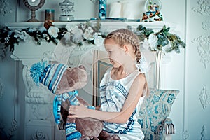 Happy child girl with toy in christmas decoration room. Toned photo