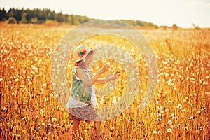 Happy child girl walking on summer meadow with dandelions. Rural country style scene, outdoor activities