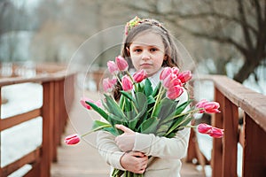 Happy child girl on warm winter forest walk, soft toned