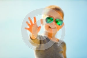 A Happy child in glasses from the sun on nature in the park travel