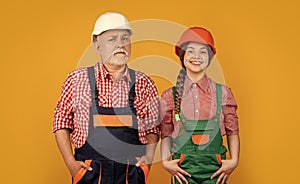 happy child and granddad builder in helmet on yellow background. labor day photo