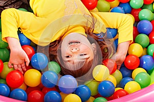 Happy child in group colourful ball.