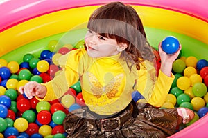 Happy child in group colourful ball.