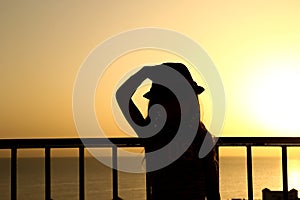 Happy child in hat silhouette on sea background