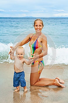 Happy child have fun with mother on sea beach