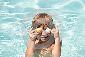 Happy child having fun at swimming pool on summer day. Children playing in blue sea water. Funny kids face. Covered eyes